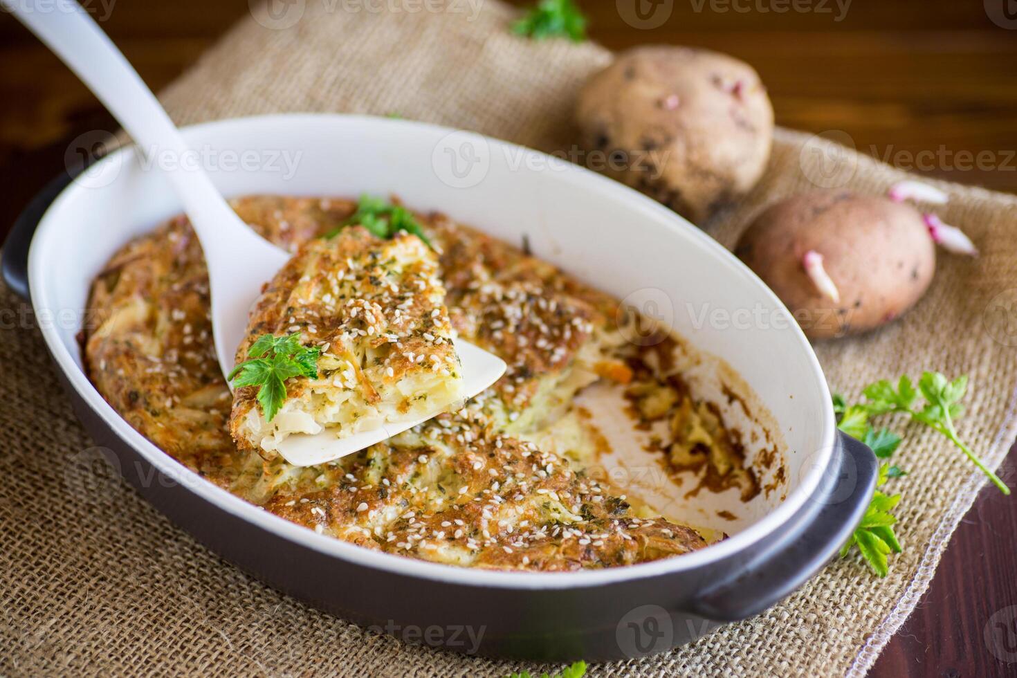 potato casserole with cabbage and spices in a ceramic form photo