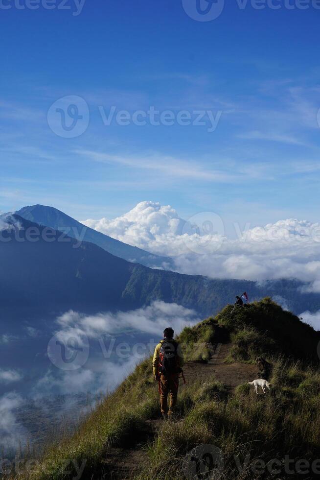 Peak Paradise, Asian Model on Mount Batur Summit with Ocean of Clouds under Azure Sky photo