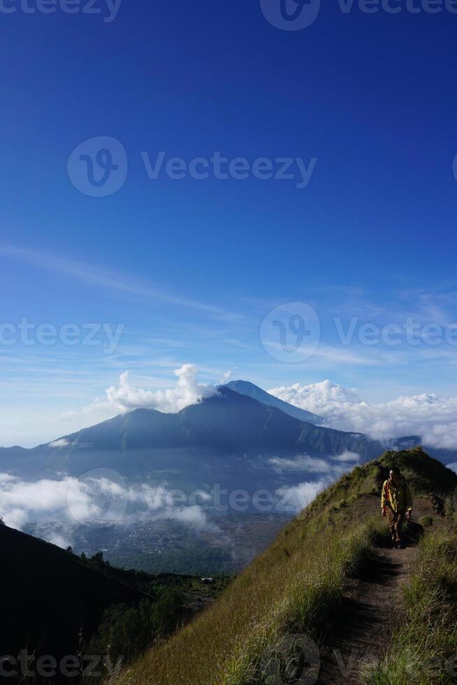Peak Paradise, Asian Model on Mount Batur Summit with Ocean of Clouds under Azure Sky photo