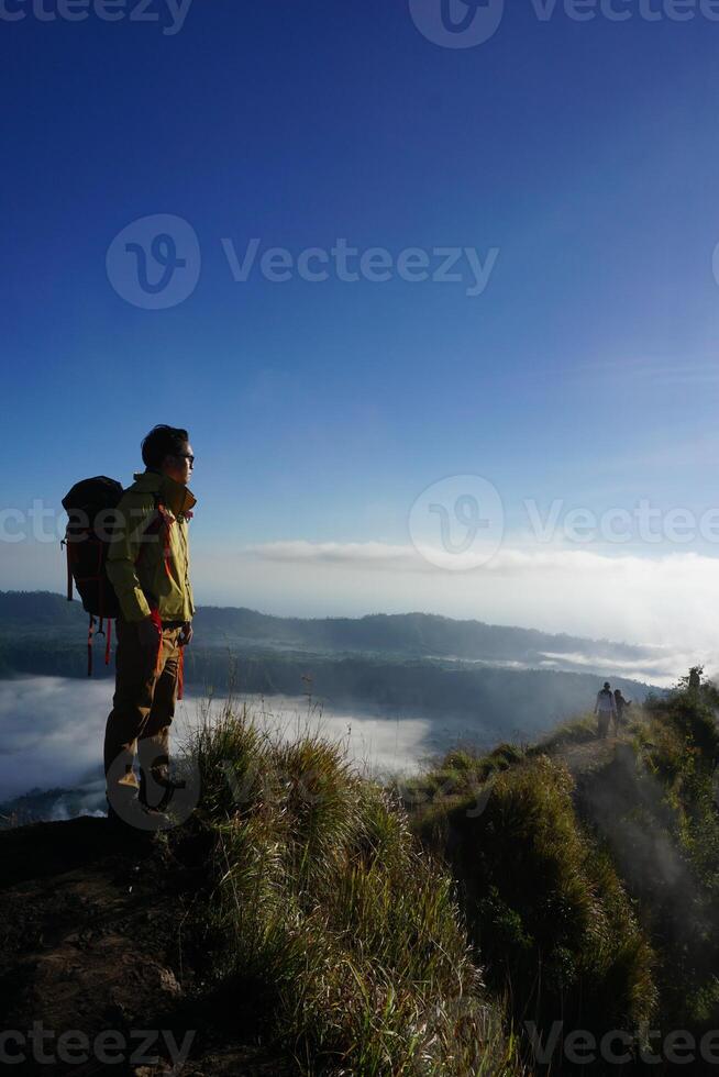 Peak Paradise, Asian Model on Mount Batur Summit with Ocean of Clouds under Azure Sky photo