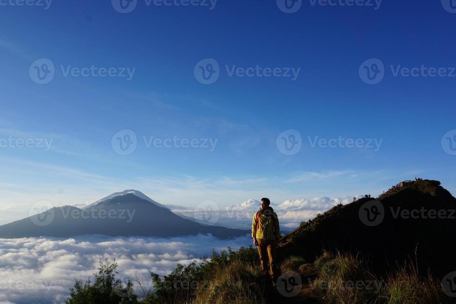 Peak Paradise, Asian Model on Mount Batur Summit with Ocean of Clouds under Azure Sky photo