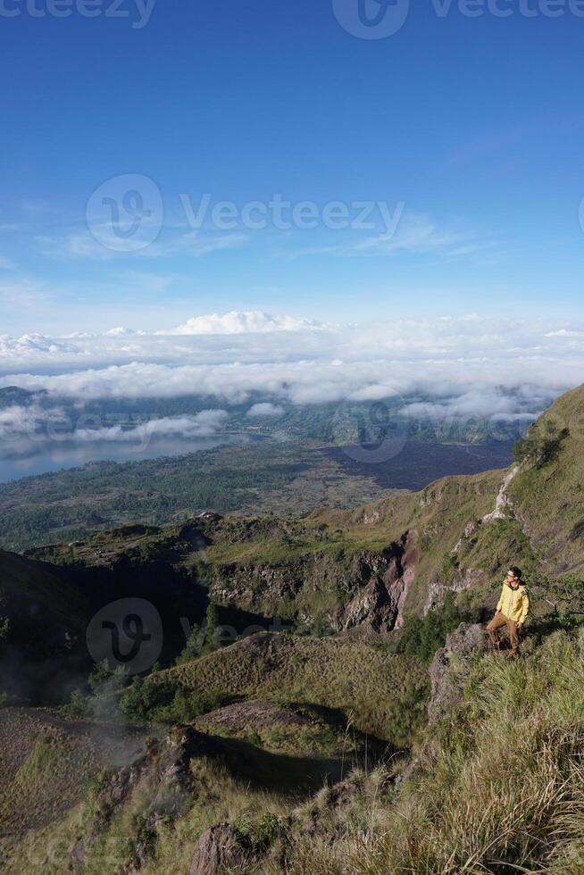 Peak Paradise, Asian Model on Mount Batur Summit with Ocean of Clouds under Azure Sky photo