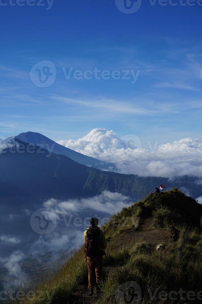 Peak Paradise, Asian Model on Mount Batur Summit with Ocean of Clouds under Azure Sky photo