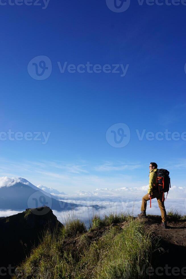 Peak Paradise, Asian Model on Mount Batur Summit with Ocean of Clouds under Azure Sky photo