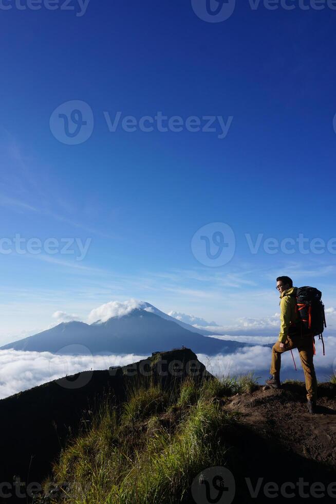 Peak Paradise, Asian Model on Mount Batur Summit with Ocean of Clouds under Azure Sky photo