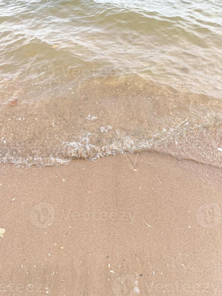 Soft wave of blue ocean on sandy beach. Background. photo