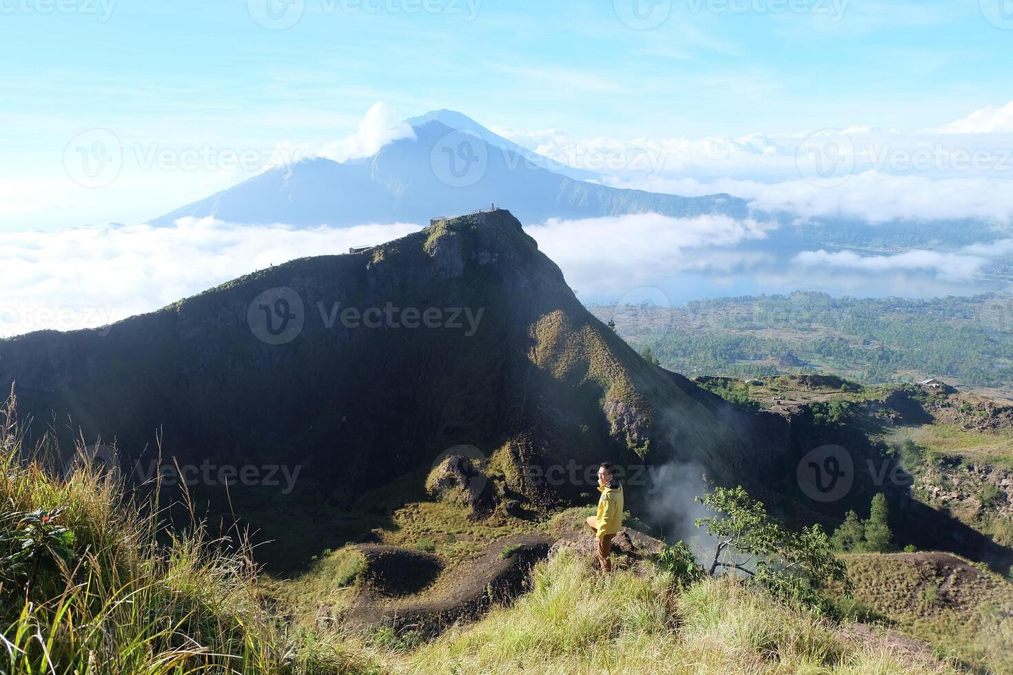 Peak Paradise, Asian Model on Mount Batur Summit with Ocean of Clouds under Azure Sky photo