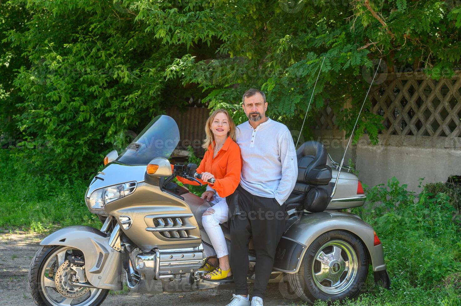 happy husband and wife sitting on a motorcycle photo