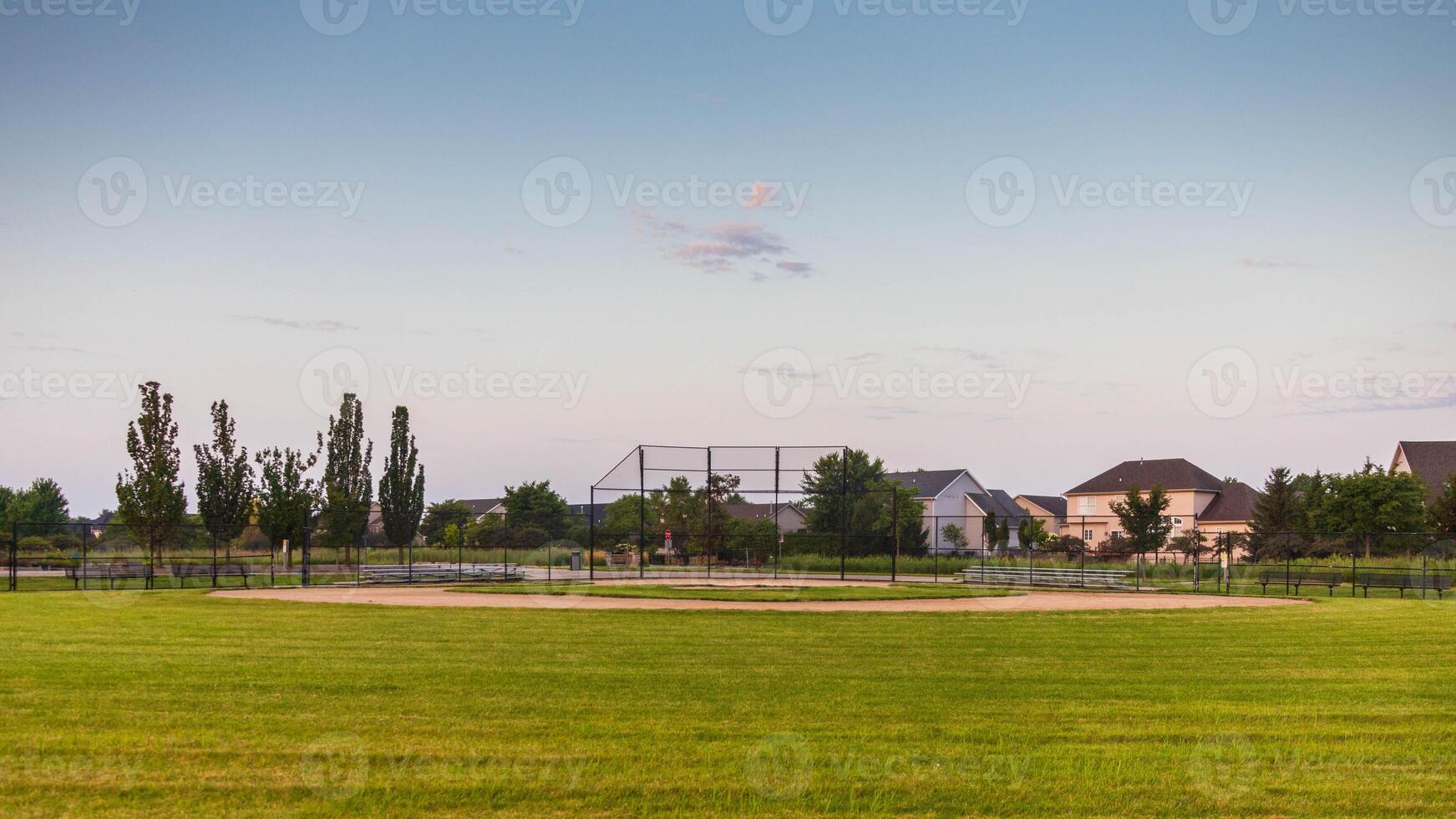 looking in towards home plate of this baseball field from right field in the early morning photo