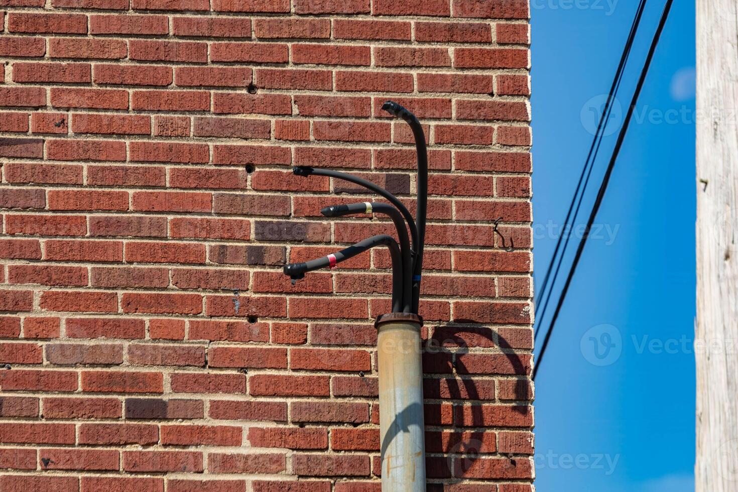 conduit on the side of a building with wires sticking out photo