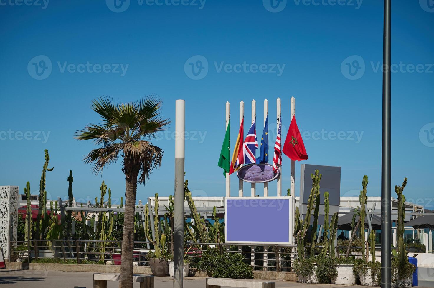 Background with flags of different countries on the promenade, over blue sky background photo