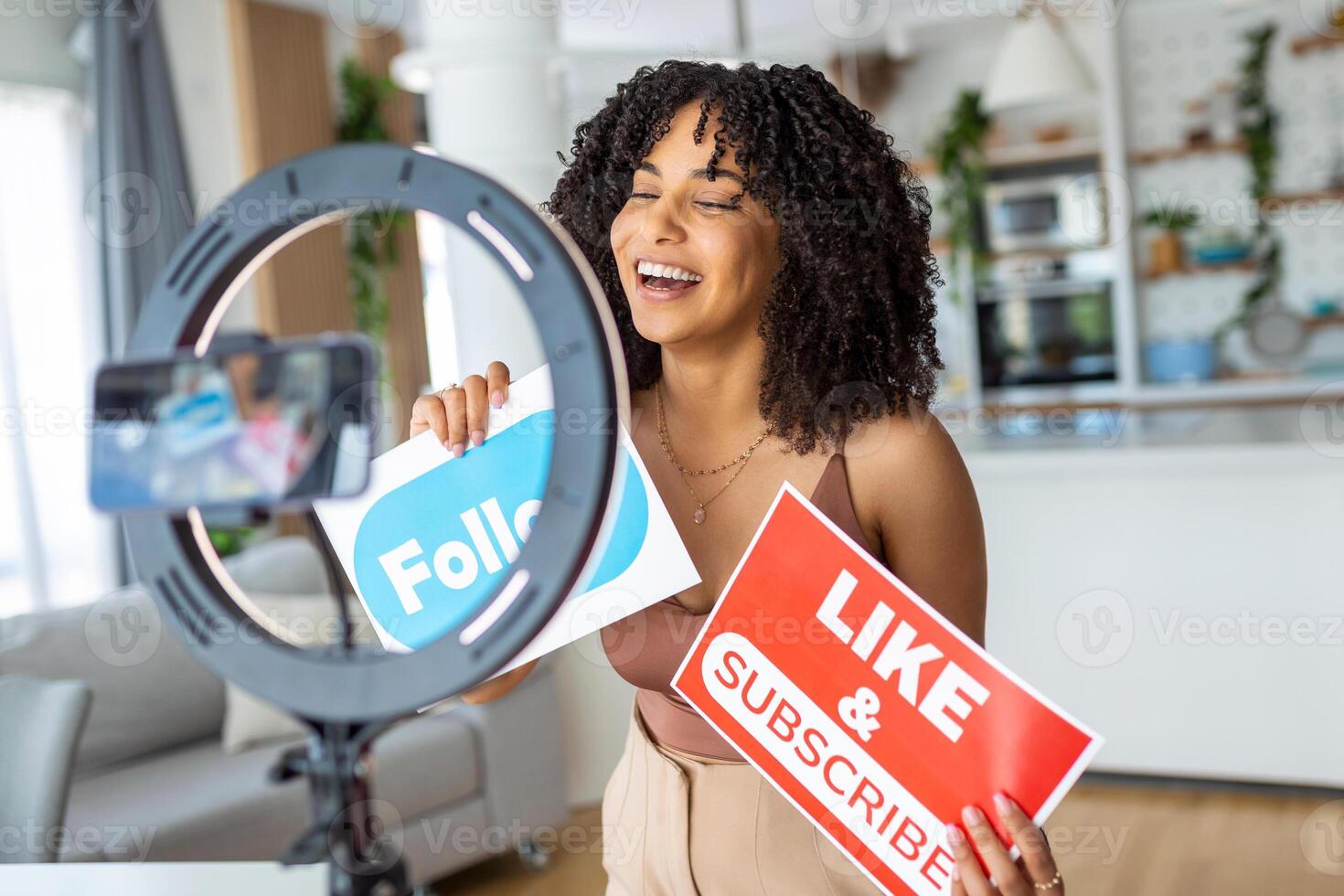 Young female influencer using her smart phone for filming a vlog post. photo