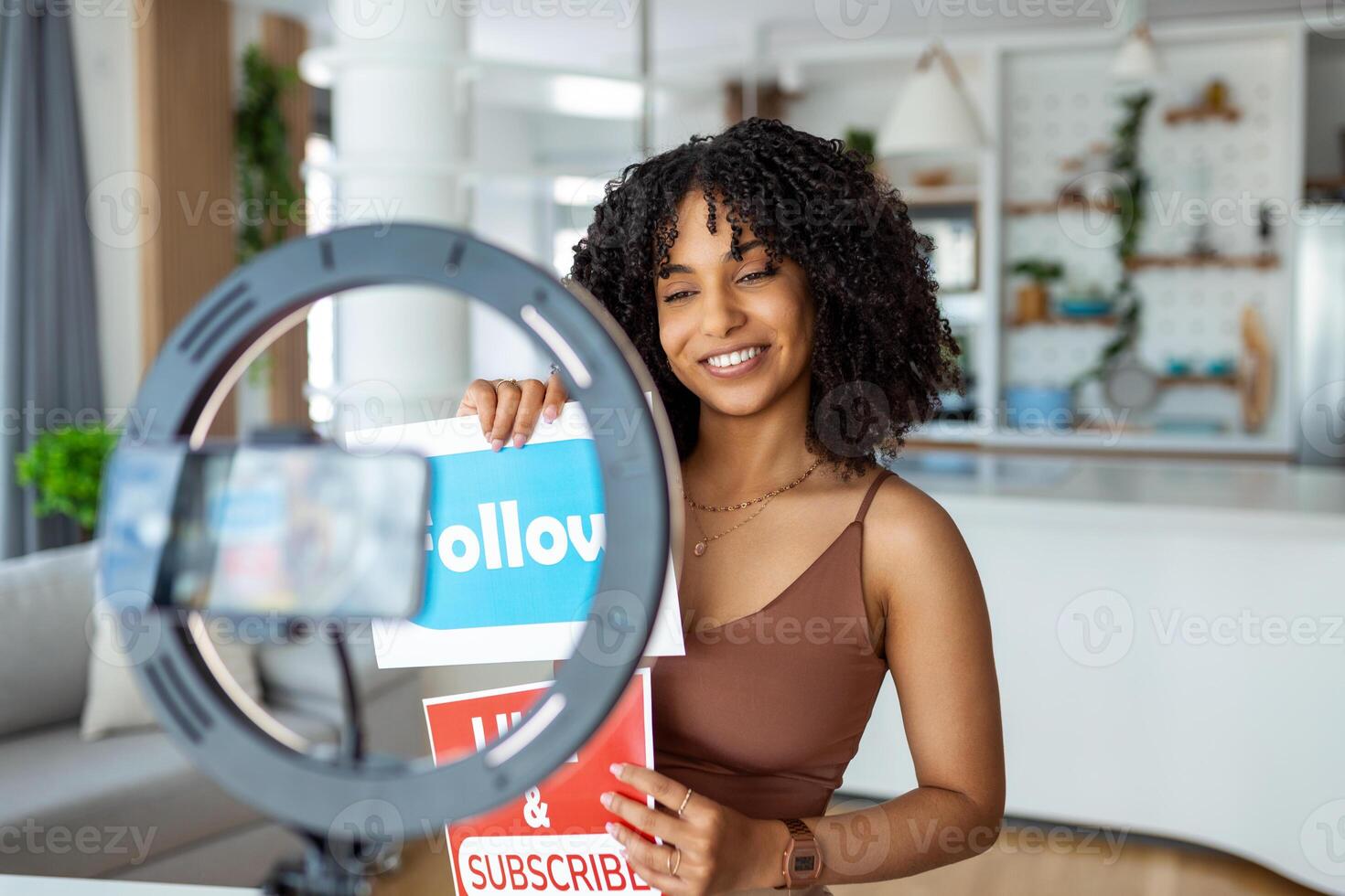 Young female influencer using her smart phone for filming a vlog post. photo