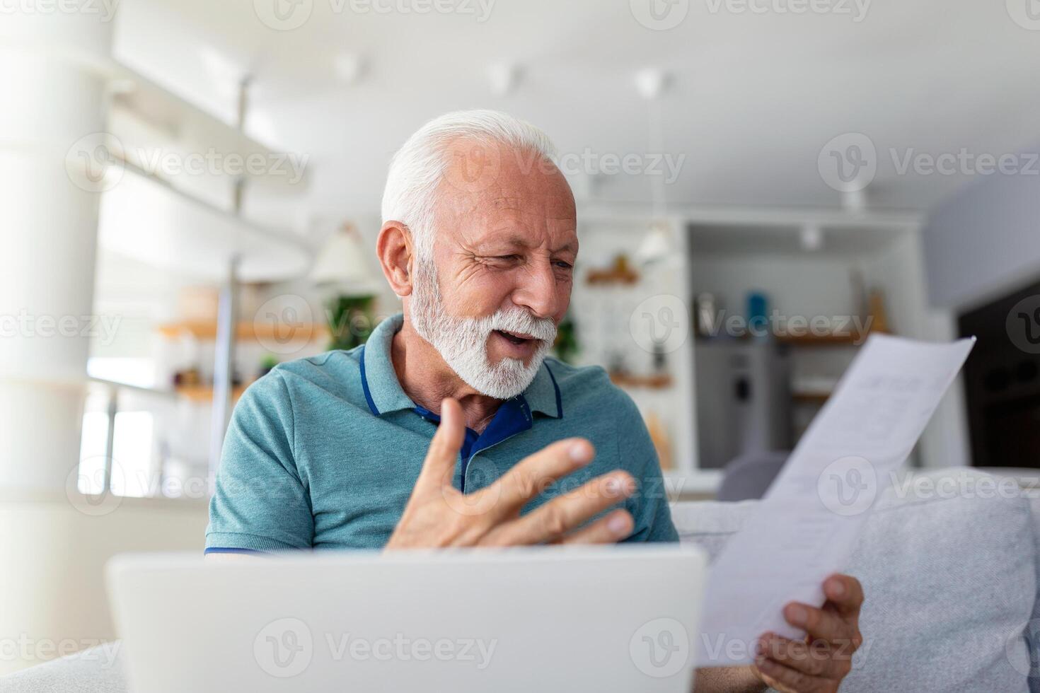 Surprised laughing happy old mature retired man looking through paper document, feeling excited analyzing financial information, getting taxes refund or bank loan approval at home. photo