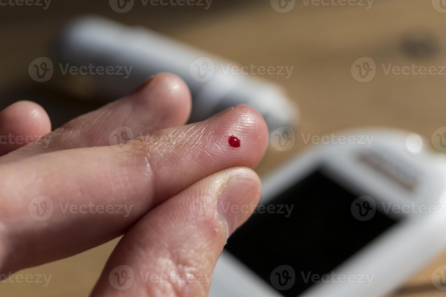 Woman pricking her finger to check blood glucose level with glucometer, test blood glucose for diabetes photo