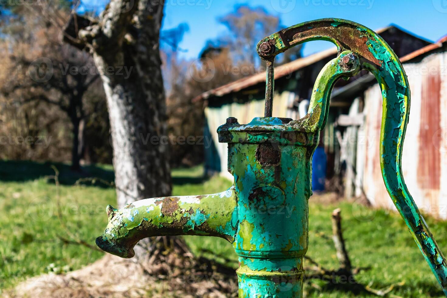 Old hand water pump on a well in the garden, watering and saving water, rural environnement photo