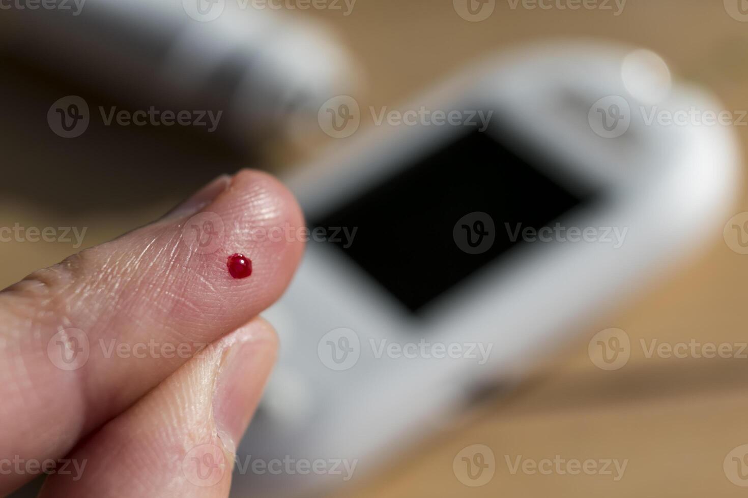 Woman pricking her finger to check blood glucose level with glucometer, test blood glucose for diabetes photo