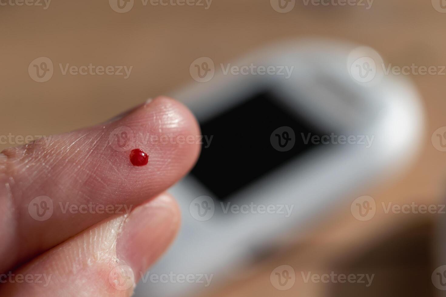Woman pricking her finger to check blood glucose level with glucometer, test blood glucose for diabetes photo