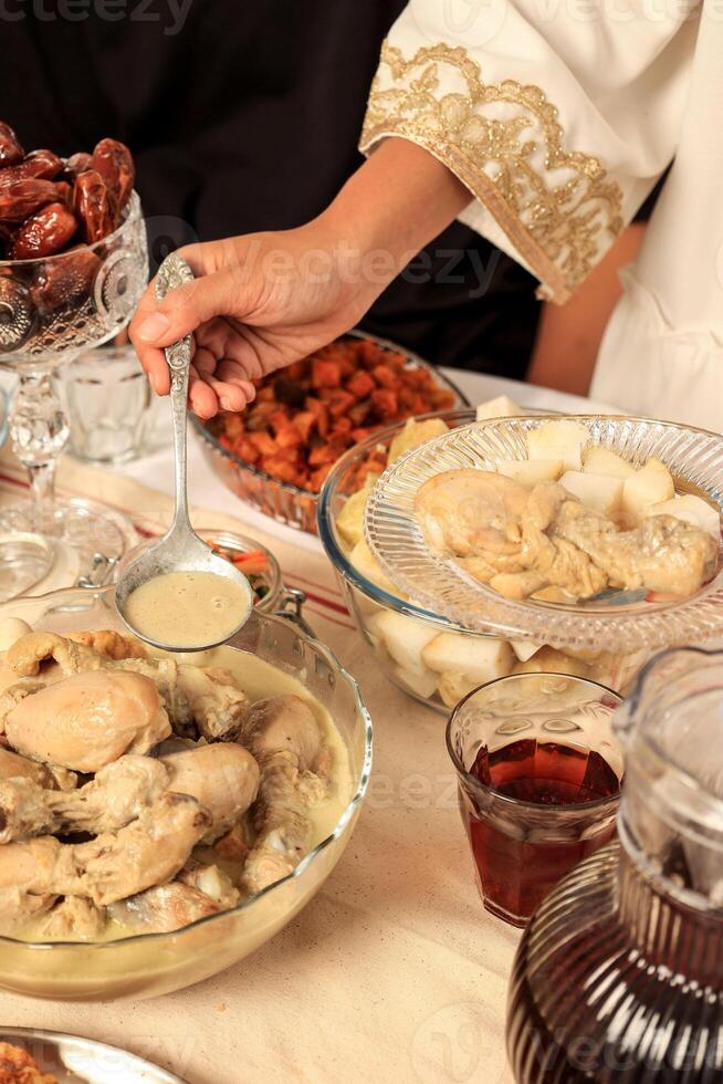 Female Indonesian Serving Opor, Indonesian Chicken Curry for Eid Al Fitr Celebration photo