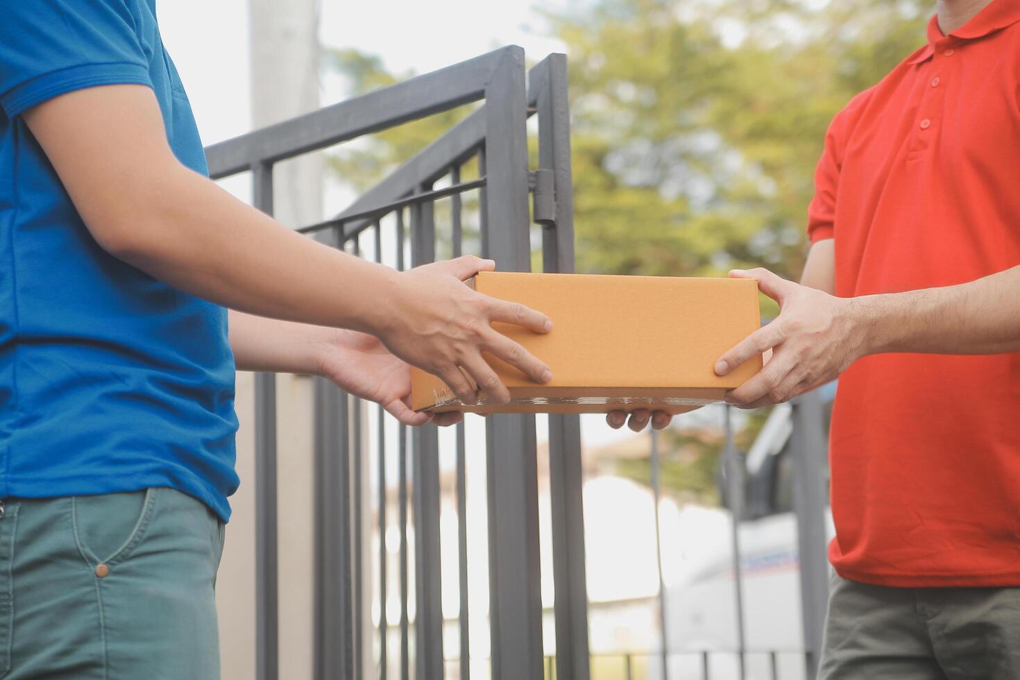 Asian delivery express courier young man use giving boxes to woman customer he wearing protective face mask at front home photo