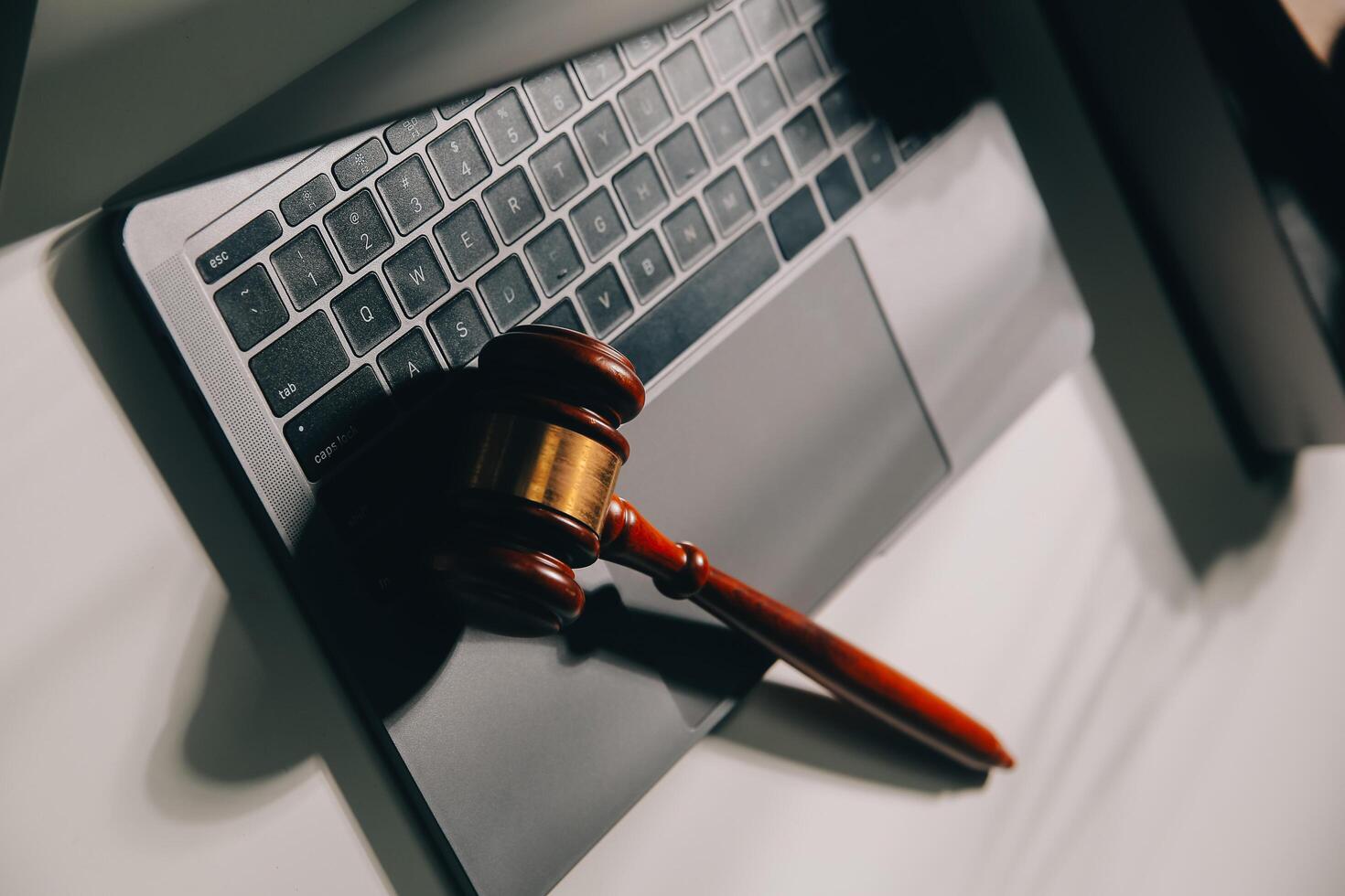 image of judge's hammer, scales lady of justice, law book, laptop computer and contract documents with pen concept of law and justice. photo