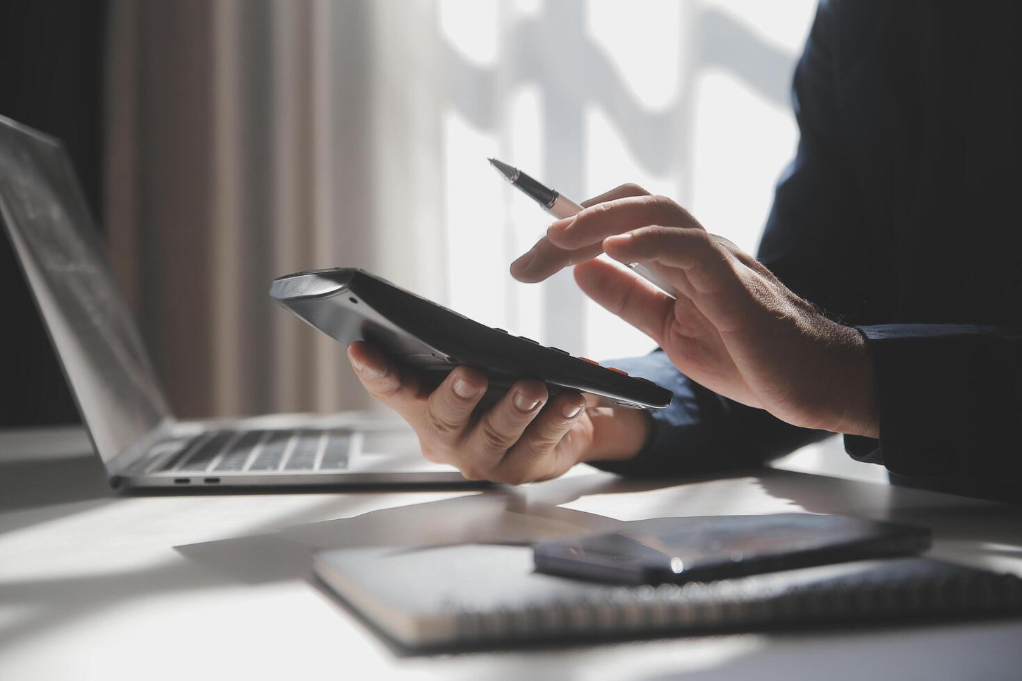 businessman working on desk office with using a calculator to calculate the numbers, finance accounting concept photo