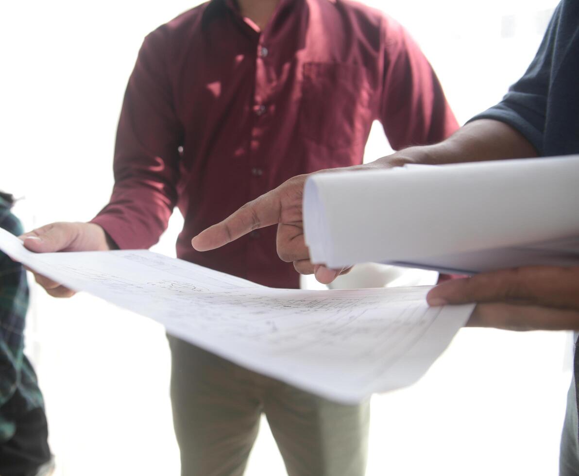 Diverse Team of Specialists Use Laptop on Construction Site. Real Estate Building Project with Engineer Investor and Businessman Checking Area, working on Civil Engineering, Discussing Strategy Plan photo