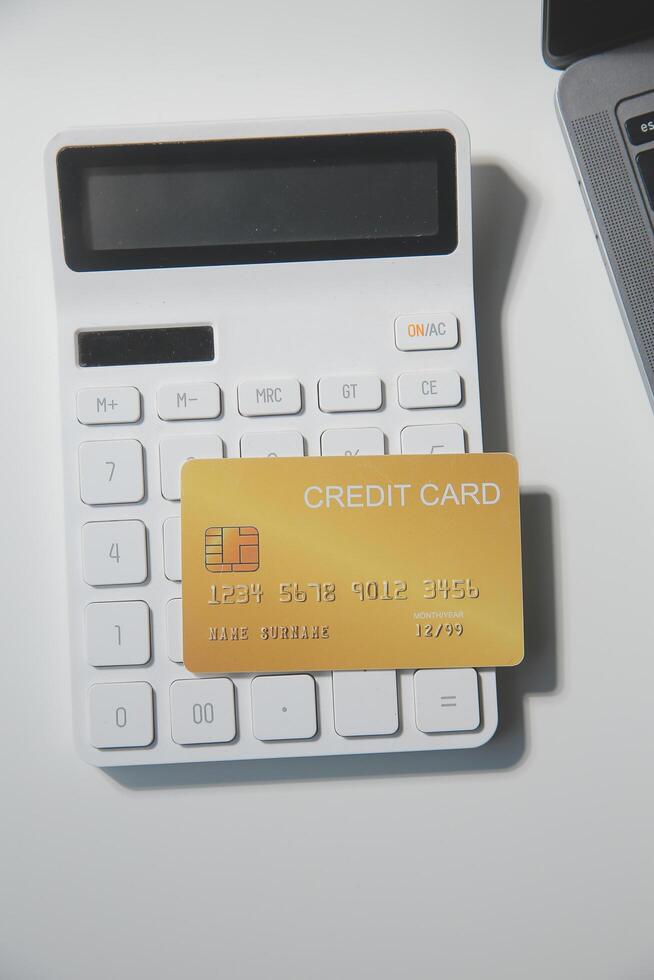 Calculator on a dark background, plastic cards and banknotes photo