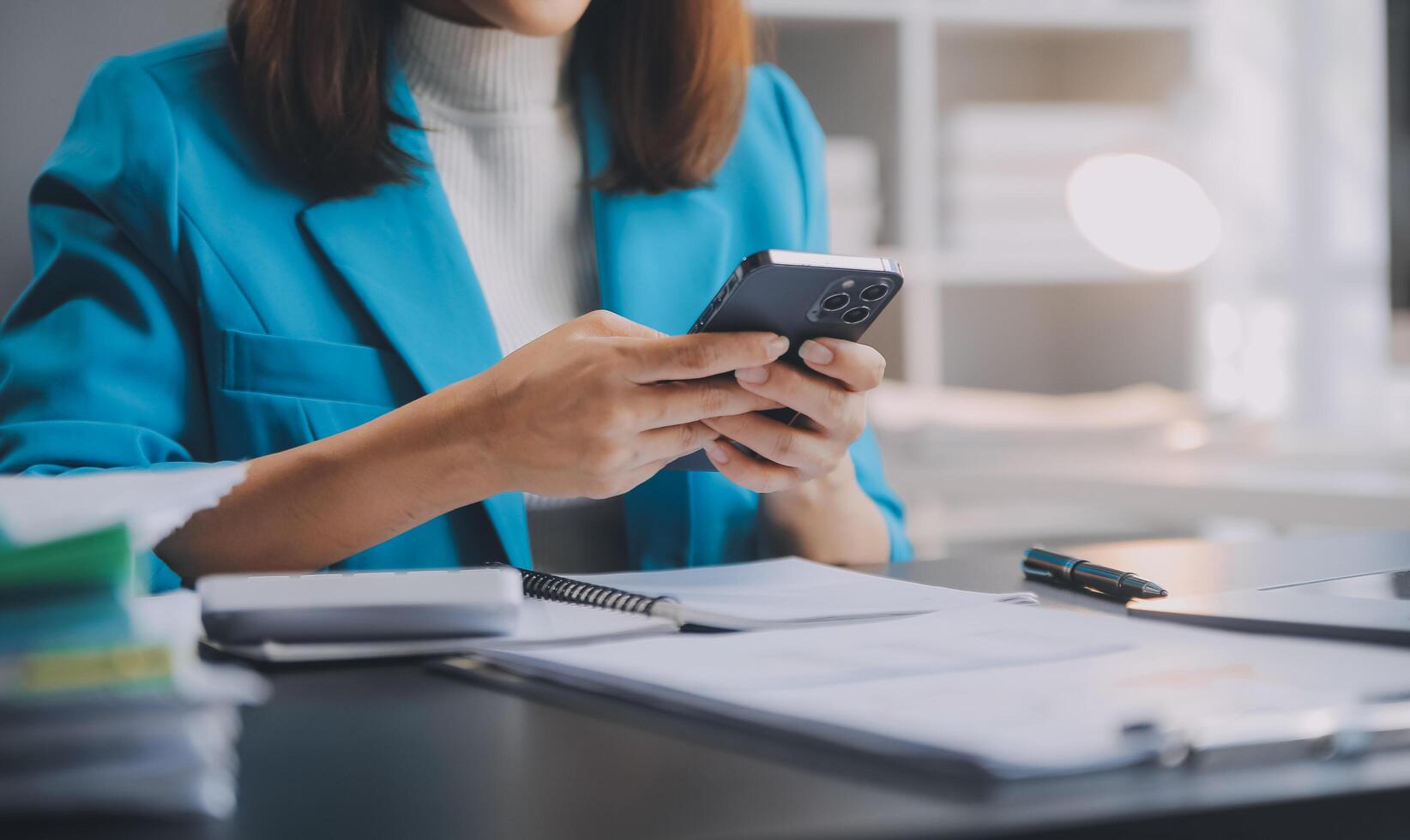 Asian Business woman using calculator and laptop for doing math finance on an office desk, tax, report, accounting, statistics, and analytical research concept photo