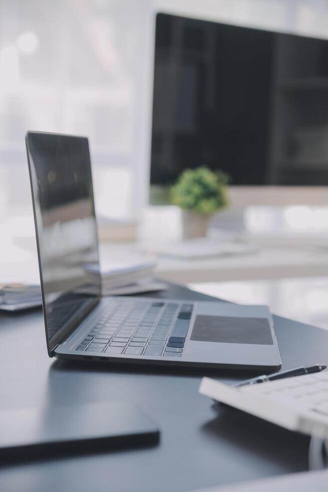 Asian Business woman using calculator and laptop for doing math finance on an office desk, tax, report, accounting, statistics, and analytical research concept photo