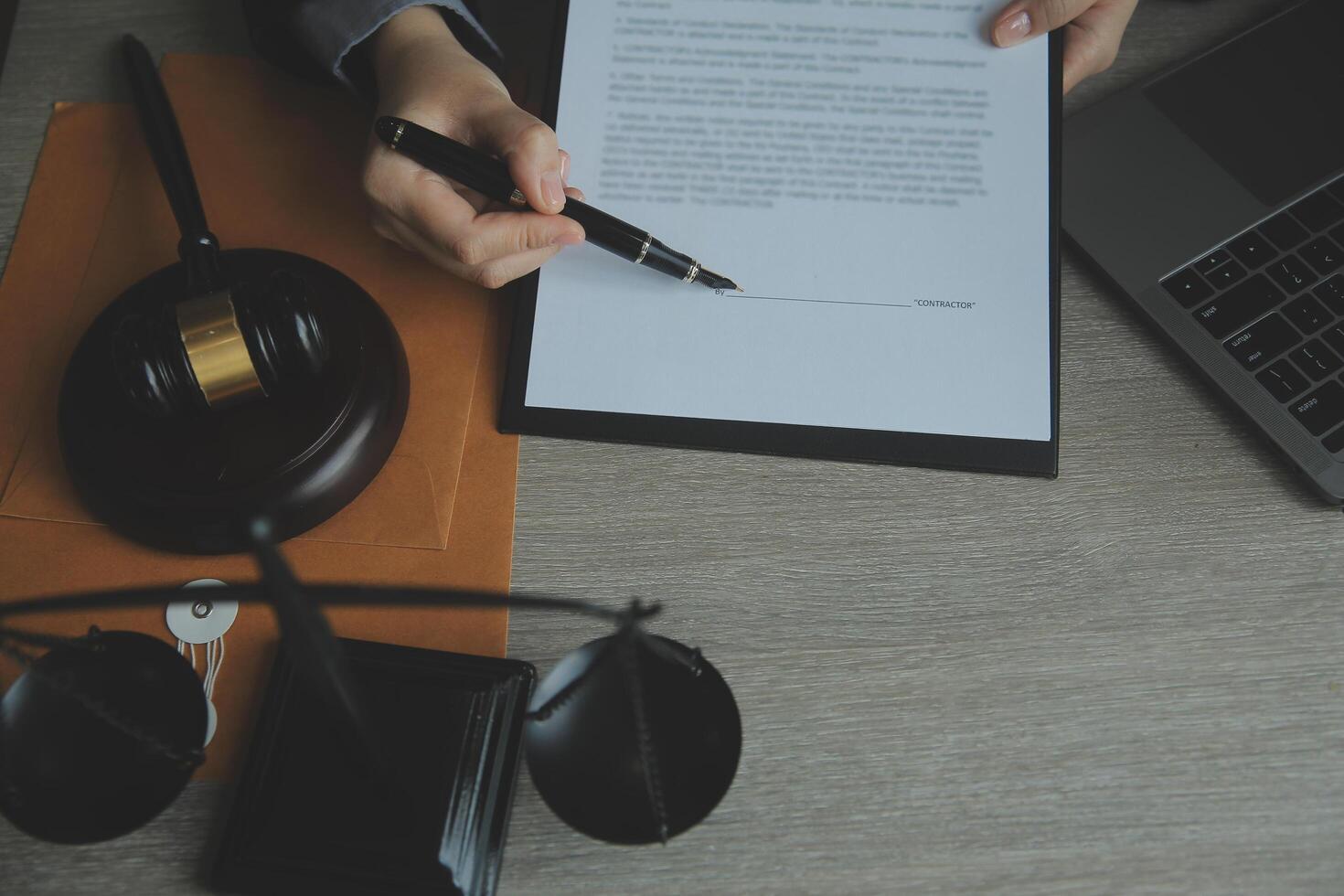 Business and lawyers discussing contract papers with brass scale on desk in office. Law, legal services, advice, justice and law concept picture with film grain effect photo