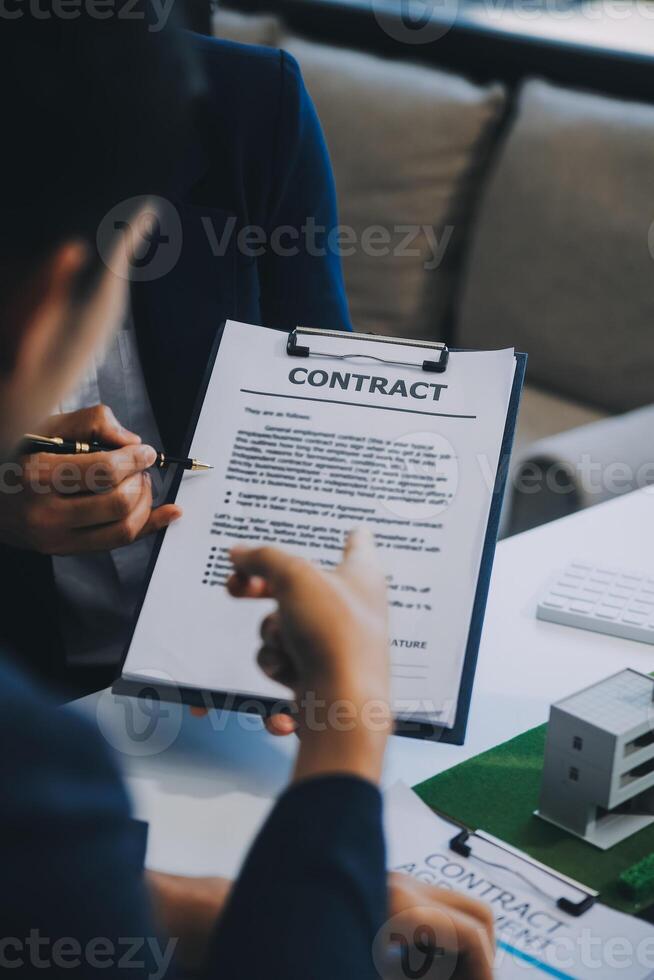 Real estate agent talked about the terms of the home purchase agreement and asked the customer to sign the documents to make the contract legally, Home sales and home insurance concept. photo