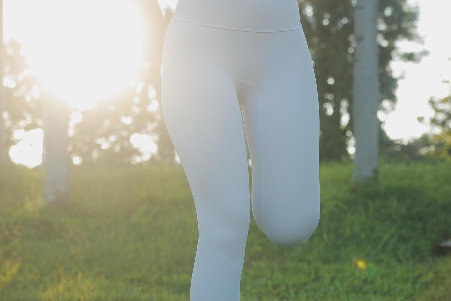 Young fitness woman runner stretching legs before run on city photo