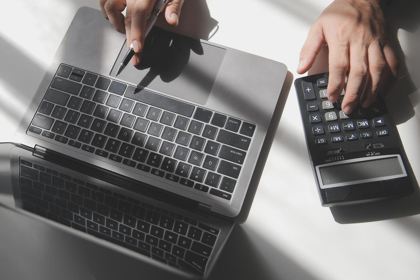 businessman working on desk office with using a calculator to calculate the numbers, finance accounting concept photo