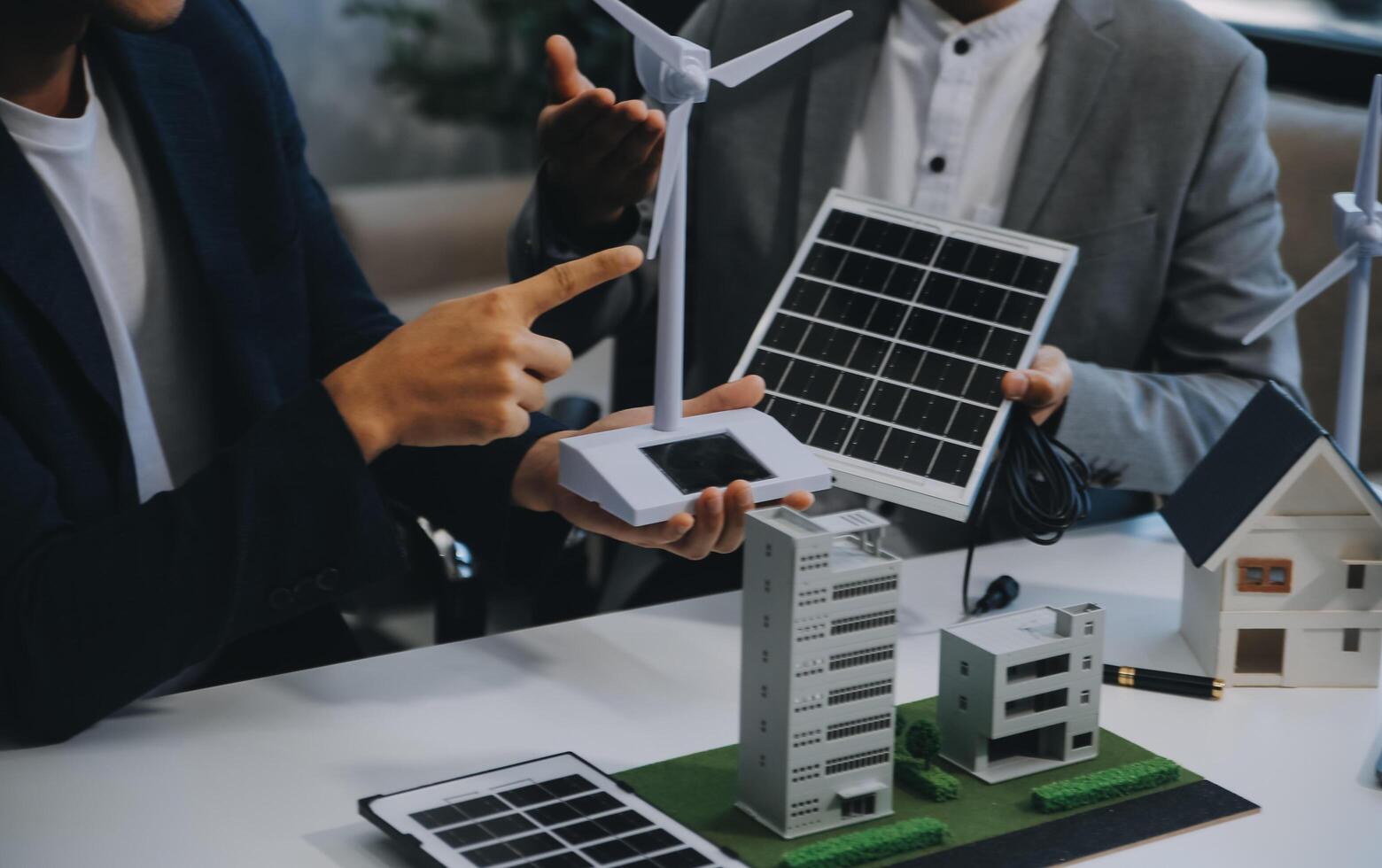 Two Young Engineers Expertise in Solar Cell Installation Meetings and Discussion in The Job. Planning to Install Solar Photovoltaic Panels on Roof Top in The Office Room with Factory Building Plan. photo