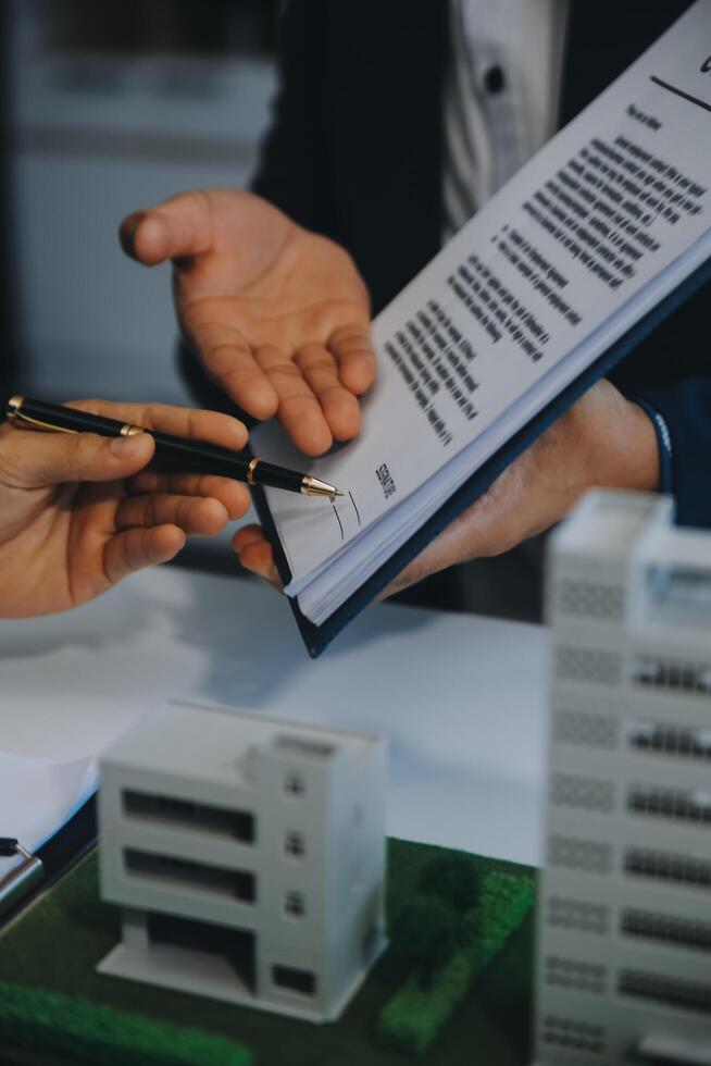 Real estate agent talked about the terms of the home purchase agreement and asked the customer to sign the documents to make the contract legally, Home sales and home insurance concept. photo