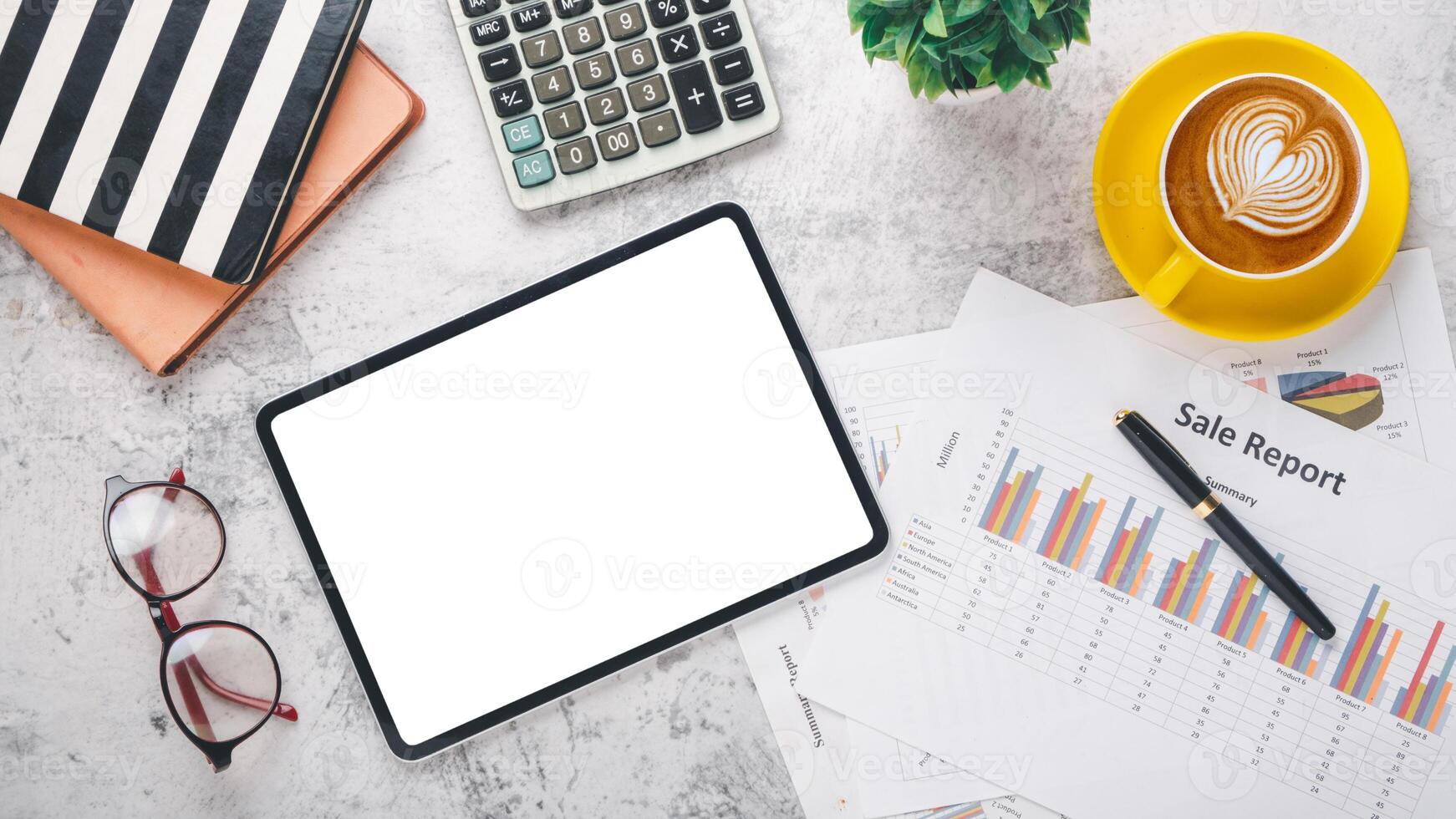 Overhead view of a well-organized desk featuring a digital tablet with a blank screen, financial reports, a calculator, and a cup of coffee, symbolizing strategic business planning and analysis. photo