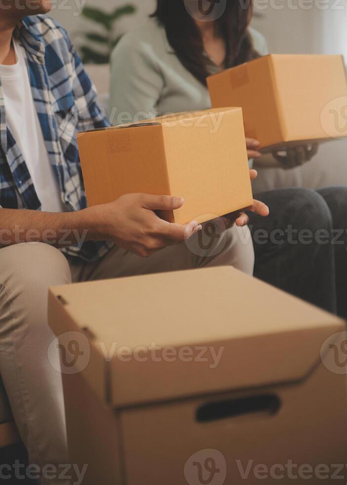 Two Asian blogger showing clothes in front of the camera to recording vlog video live streaming at her shop. Online Shopping Cart notion. on sofa at home photo