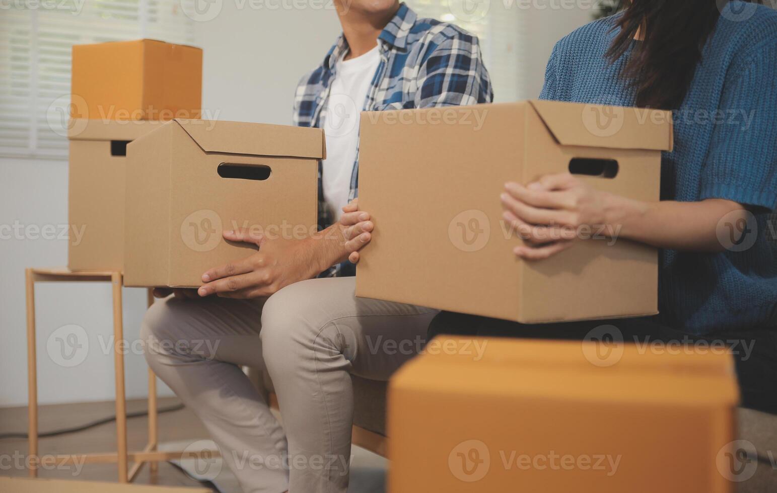 Two Asian blogger showing clothes in front of the camera to recording vlog video live streaming at her shop. Online Shopping Cart notion. on sofa at home photo