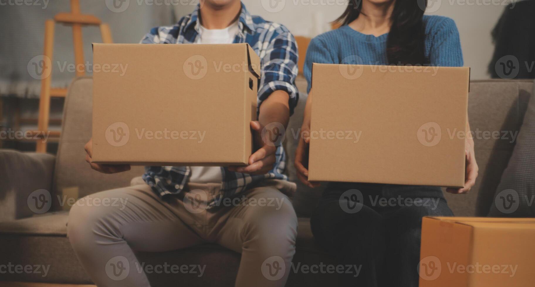 Two Asian blogger showing clothes in front of the camera to recording vlog video live streaming at her shop. Online Shopping Cart notion. on sofa at home photo