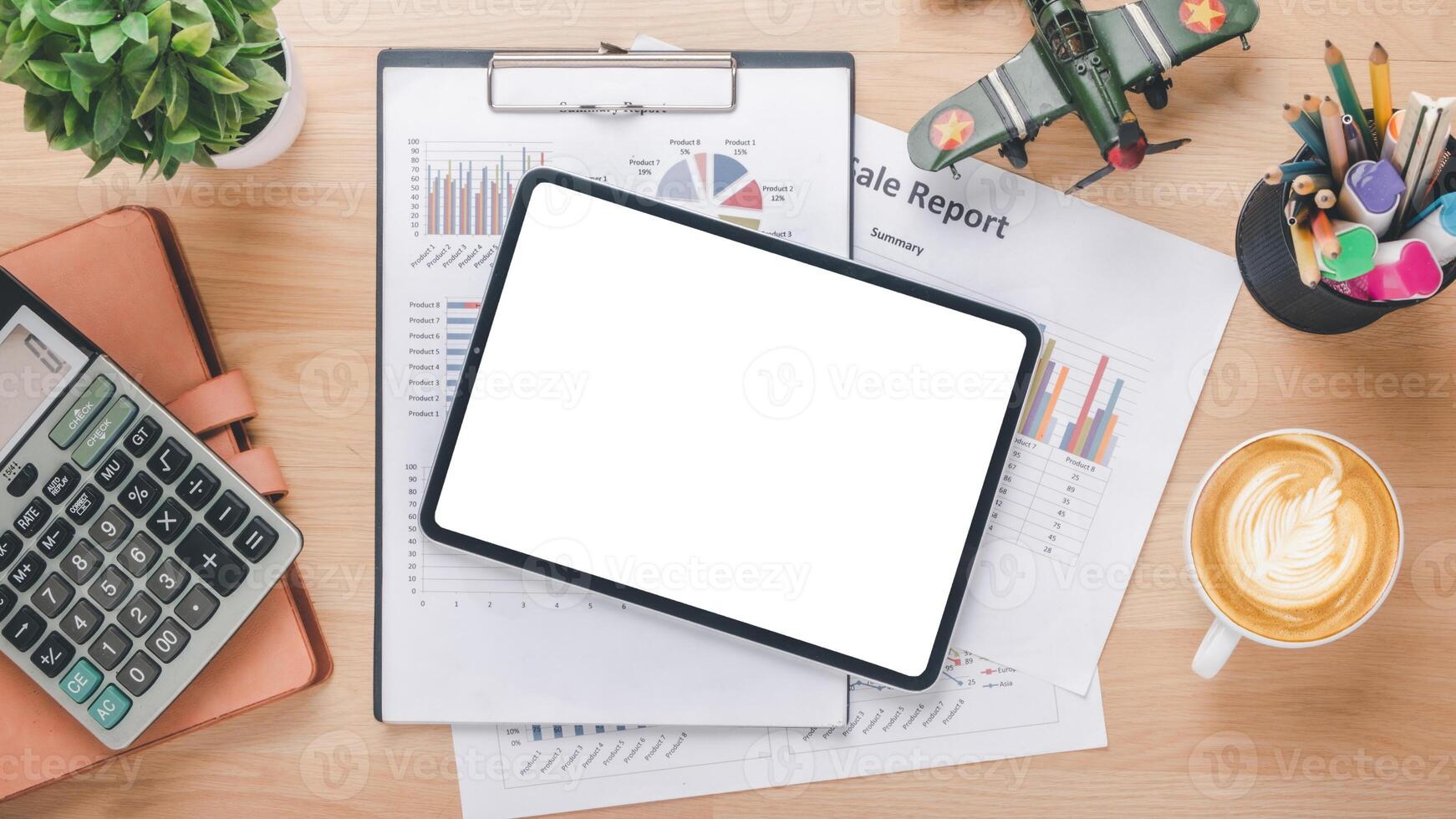 Overhead view of a well-organized desk featuring a digital tablet with a blank screen, financial reports, a calculator, and a cup of coffee, symbolizing strategic business planning and analysis. photo