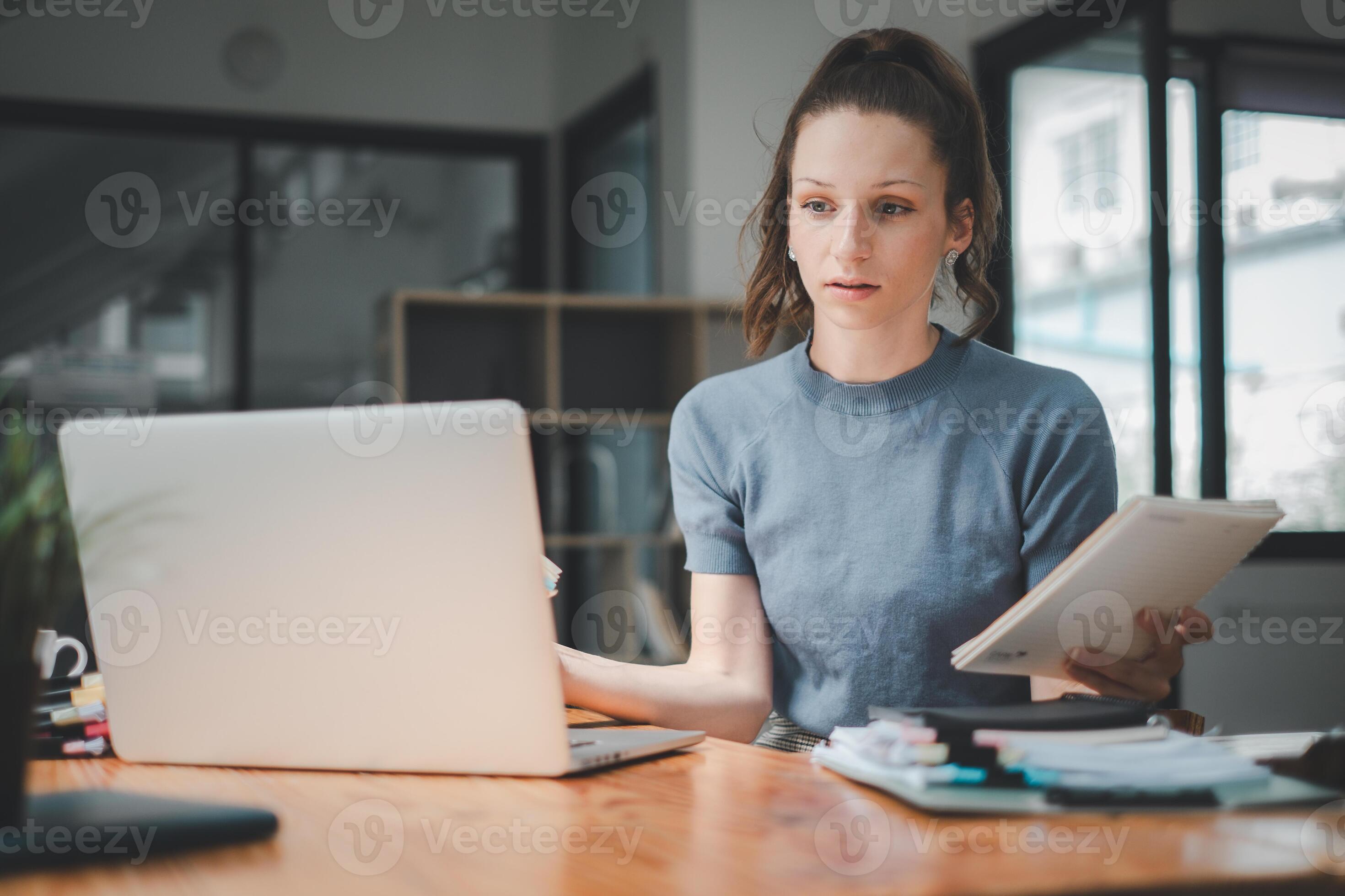 A diligent woman reviews her notes with an attentive eye, cross