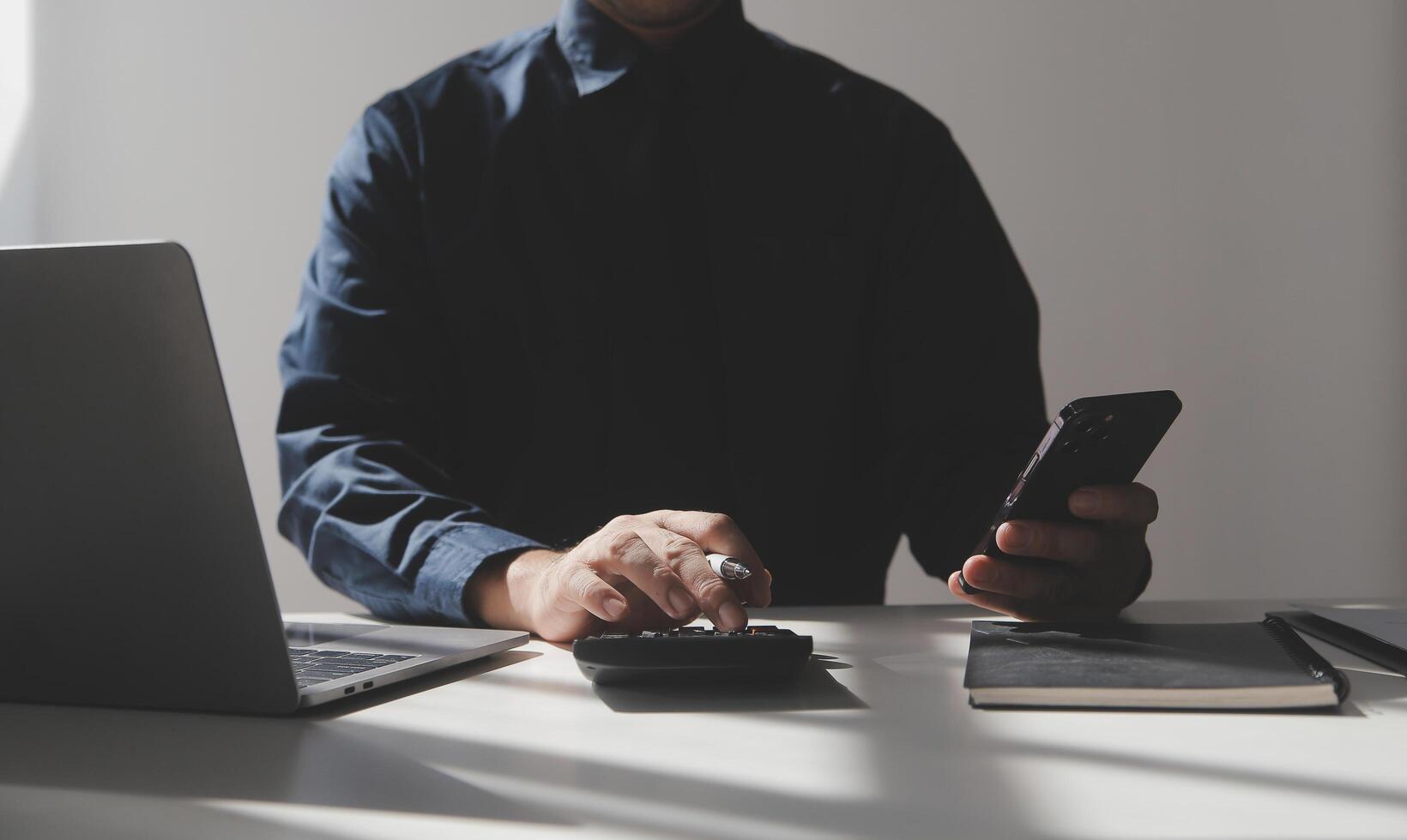 businessman working on desk office with using a calculator to calculate the numbers, finance accounting concept photo