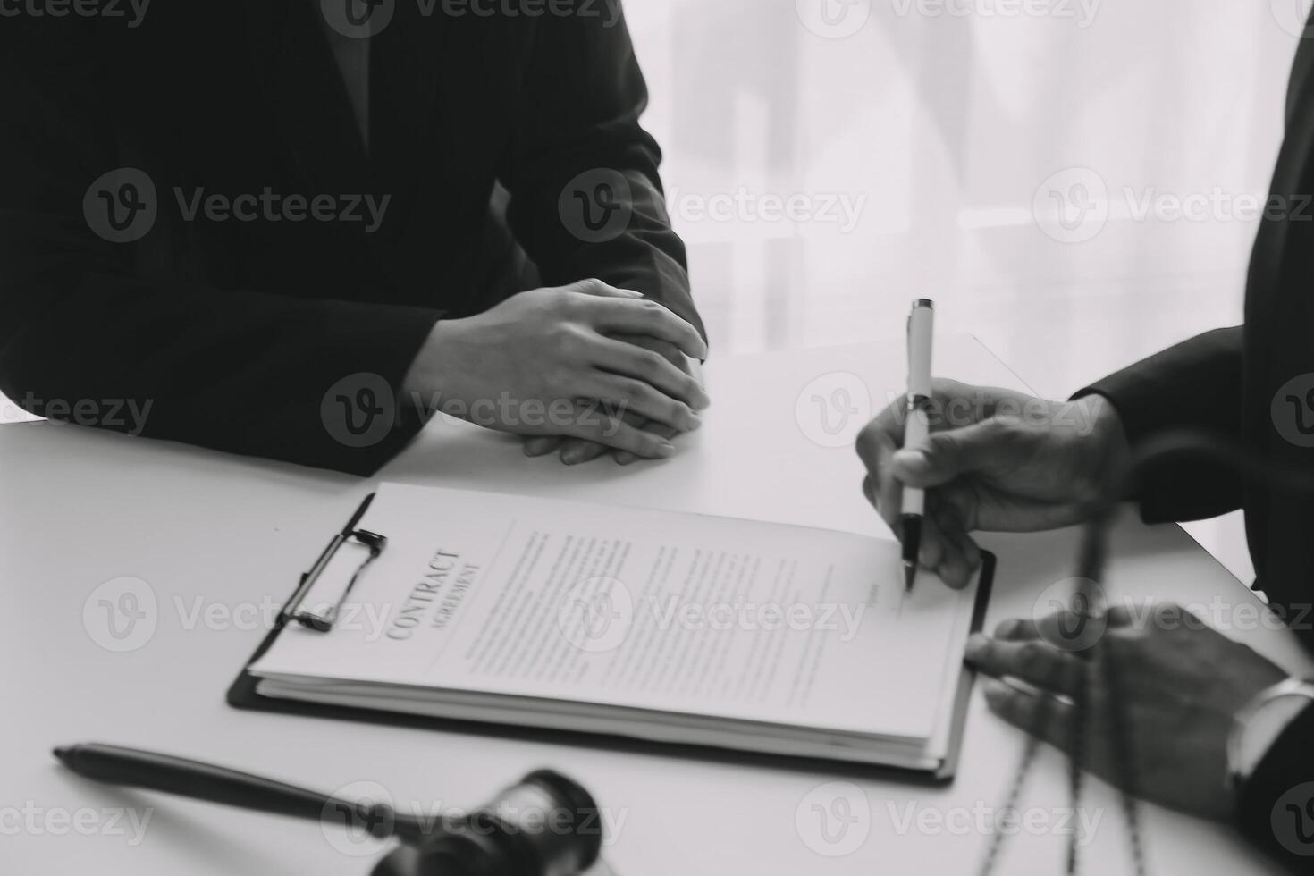 concepto de justicia y derecho. El asesor legal presenta al cliente un contrato firmado con mazo y derecho legal o una reunión de equipo legal en el bufete de abogados en segundo plano. foto