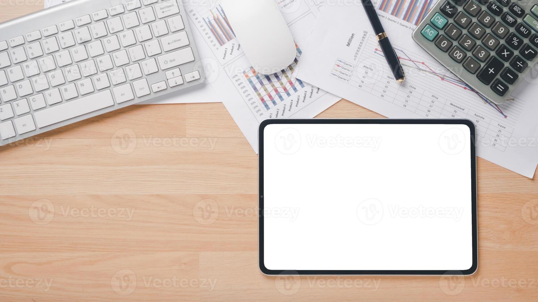 Tablet with blank screen, pen, calculator, notebook, mouse and keyboard on office desk workplace. Top view flat lay with copy space. photo