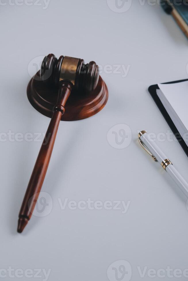 concepto de justicia y derecho. El asesor legal presenta al cliente un contrato firmado con mazo y derecho legal o una reunión de equipo legal en el bufete de abogados en segundo plano. foto