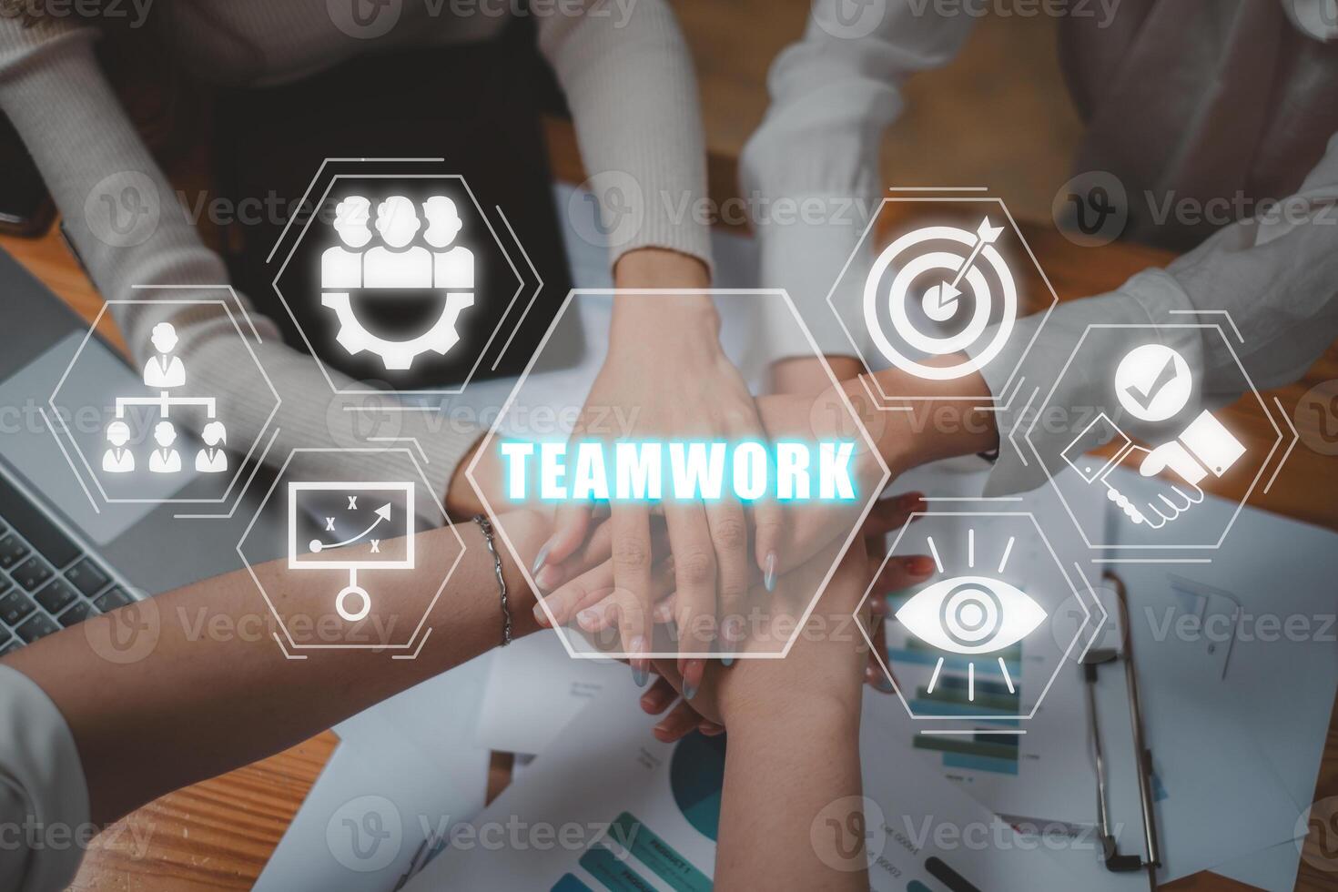 Teamwork concept, Positive diverse business team putting their hands on top of each other with teamwork icon on virtual screen. photo