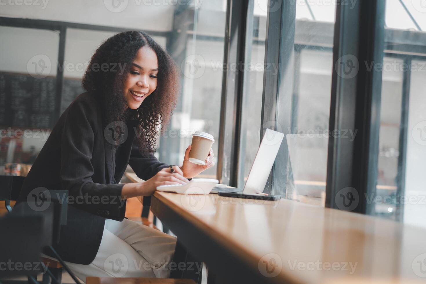 Business analytics concept, Content businesswoman in a bright office space multitasking with a calculator and laptop, epitomizing modern efficiency. photo