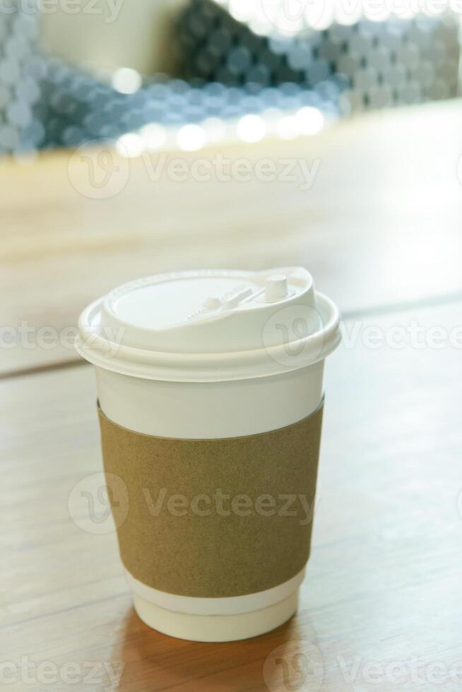 hot coffee cup cover by brown paper protect heat tempurature on wood table photo