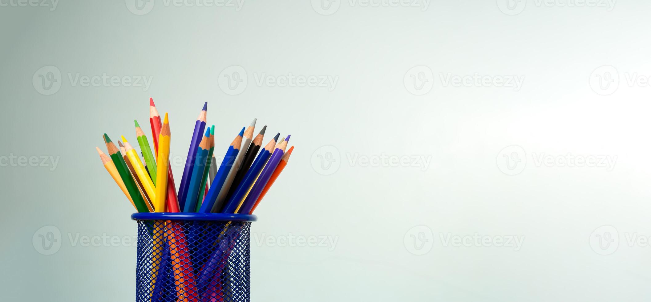 Stack of colorful textbooks and a glass of bright pencils on a white background, Concept of education, training, School tools, workspace, copy space, Banner design education concept background. photo